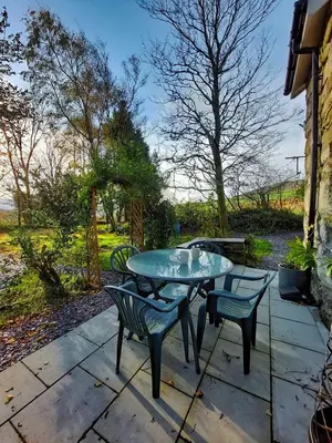 a patio with a table and chairs on a patio at Cae Tudur Remote Rural Cottage near Barmouth in Barmouth