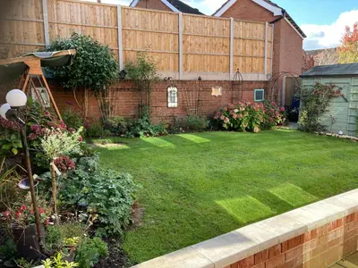 a backyard with a lawn and a fence at Ludlow House in Ludlow