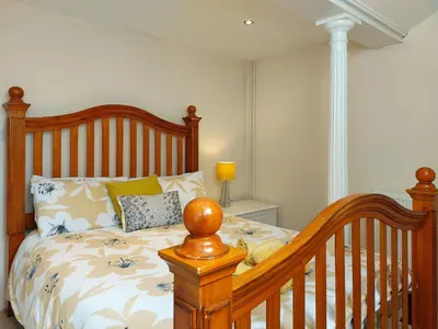 a bedroom with a wooden bed with a wooden crib at Ty Capel in Tywyn in Tywyn