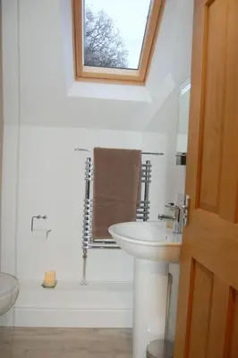a white bathroom with a sink and a shower at Anneddle Cottage in Talybont, near Barmouth in Talybont
