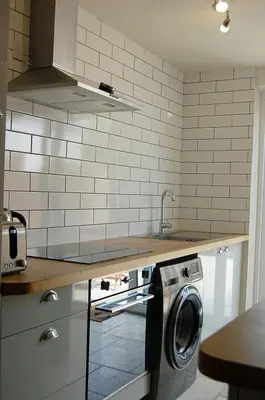 a kitchen with a sink and a washing machine at Y Bwthyn Bach Cute Stone Cottage in Tywyn in Tywyn