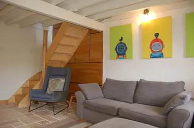 a living room with a couch and a chair at Y Bwthyn Bach Cute Stone Cottage in Tywyn in Tywyn