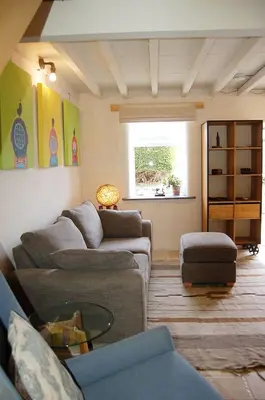 a living room with two couches and a window at Y Bwthyn Bach Cute Stone Cottage in Tywyn in Tywyn