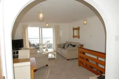 a living room with a couch and a table at Ty Traeth Beach House in Tywyn