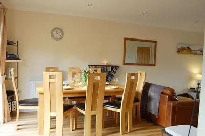 a dining room with a table and chairs and a clock at Ty Pen y Bryn in Dolgellau in Dolgellau