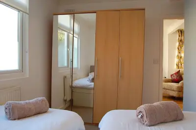 a bedroom with two beds and a large wooden closet at Tawel Fryn Bungalow near Dolgellau in Dolgellau