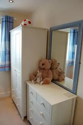 a bedroom with a dresser with teddy bears on it at Sunset Bay Beach House in Tywyn in Tywyn