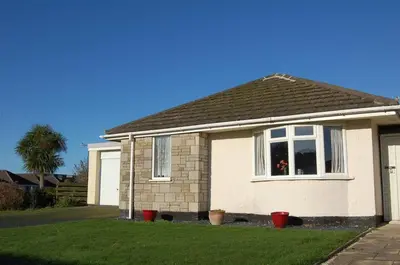 a white house with a window in a yard at Wulfrun in Tywyn
