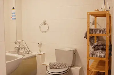 a white bathroom with a toilet and a sink at Sunny Side Up Beach House in Tywyn in Tywyn