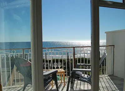 a view of the ocean from the balcony of a house at Sunny Side Up Beach House in Tywyn in Tywyn