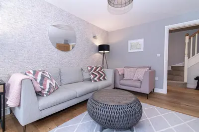 a living room with a couch and a mirror at Elegant Ludlow Haven: 4Bed Ultimate Tranquility in Ludlow