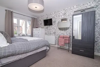 a bedroom with a bed and a tv on a wall at Elegant Ludlow Haven: 4Bed Ultimate Tranquility in Ludlow