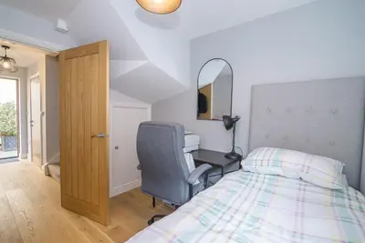 a bedroom with a bed and a desk and a chair at Elegant Ludlow Haven: 4Bed Ultimate Tranquility in Ludlow
