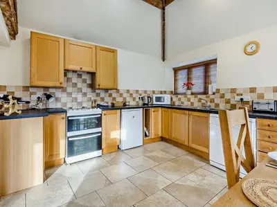 a kitchen with wooden cabinets and white appliances at 2 Bed in Shrewsbury oc-47795 in Ryton