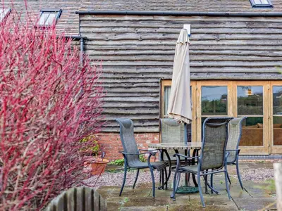 a table and chairs with an umbrella in front of a building at 2 Bed in Shrewsbury oc-47795 in Ryton