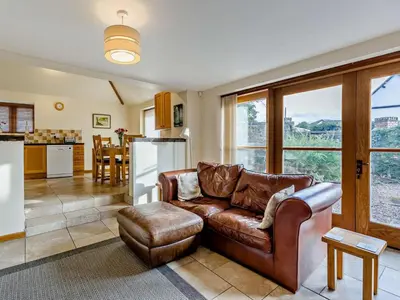 a living room with a leather couch and a kitchen at 2 Bed in Shrewsbury oc-47795 in Ryton
