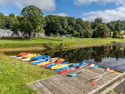 a row of canoes on the water next to a dock at 4 Bed in Bala oc-75288 in Llandderfel