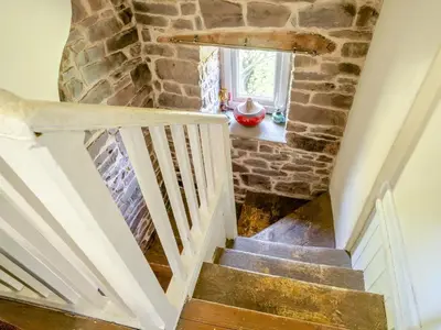 a staircase in a house with a stone wall at 2 Bed in Llanfihangel-nant-Bran BN200 in Llanfihangel-Nant-Brân
