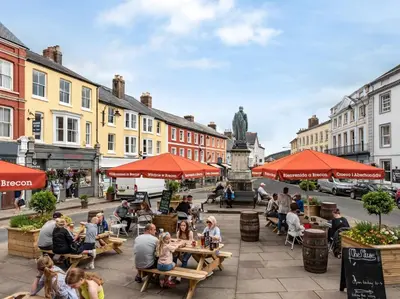 a group of people sitting at tables on a city street at 2 Bed in Llanfihangel-nant-Bran BN200 in Llanfihangel-Nant-Brân