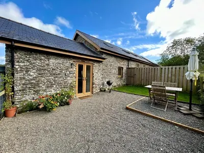 a stone house with a bench and a table at 1 Bed in Aberystwyth oc-83551 in Llanilar