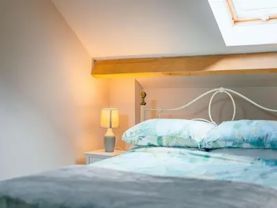 a bedroom with a bed with a white headboard and a window at 1 Bed in Aberystwyth oc-83551 in Llanilar