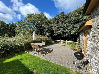 a backyard with a table and chairs and a grill at 1 Bed in Aberystwyth oc-83551 in Llanilar