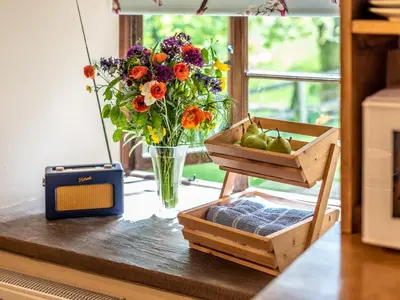 a table with a vase of flowers and a vase of pears at 4 Bed in Hereford oc-86497 in Llanveynoe