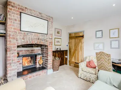 a living room with a brick fireplace and a chair at 4 Bed in Llandinam oc-51651 in Llandinam