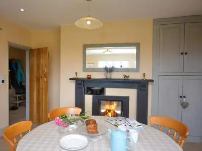 a dining room with a table and a fireplace at 4 Bed in Llandinam oc-51651 in Llandinam