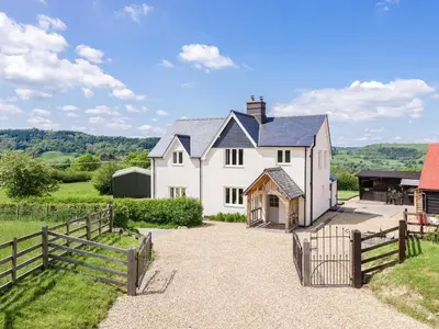an exterior view of a white house with a fence at 4 Bed in Llandinam oc-51651 in Llandinam