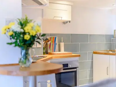 a vase of yellow flowers on a table in a kitchen at 1 Bed in Presteigne oc-53667 in Presteigne