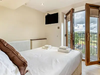 a bedroom with a bed and a tv and a window at 2 Bed in Corwen oc-77351 in Corwen