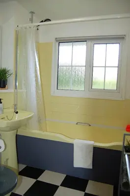 a bathroom with a tub and a sink and a window at Hafan Y Talgarth bungalow at Plas Talgarth resort in Pennal