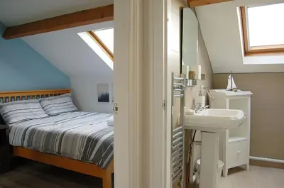 a attic bedroom with a bed and a sink at Idris View Family Holiday Home in Tywyn