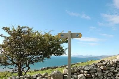 a street sign in front of a rock wall at Glan yr Afon in Dolgellau in Dolgellau