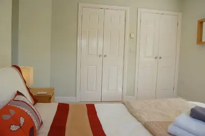 a bedroom with a bed and two white doors at Glan yr Afon in Dolgellau in Dolgellau