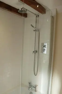 a shower with a shower head and a sink at Glyn Saron near Tywyn in Bryn-crug
