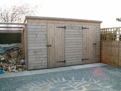 a pair of wooden garage doors in a backyard at Glyn Saron near Tywyn in Bryn-crug