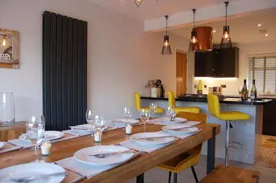 a dining room table with plates and wine glasses at Paradwys in Dolgellau in Dolgellau