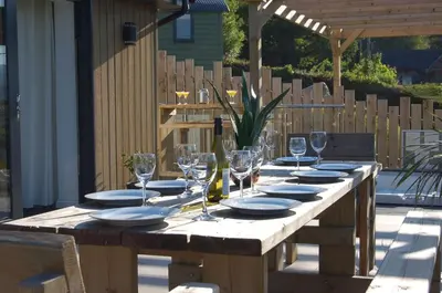a wooden table with plates and wine glasses on it at Paradwys in Dolgellau in Dolgellau