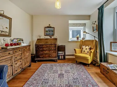 a living room with a dresser and a yellow chair at 6 Bed in Brecon oc-bn171 in Llanspyddid