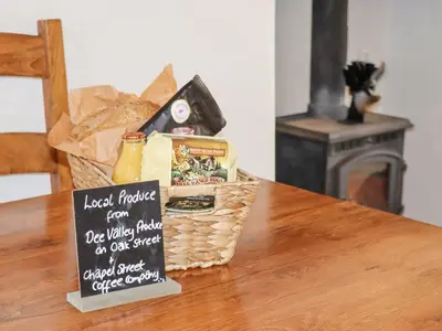a basket of bread and a sign on a table at No 9 On The Riverbank in Llangollen