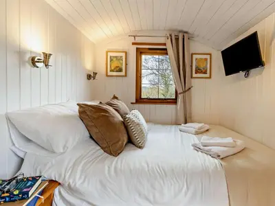 a large white bed in a room with a window at 1 Bed in Llanidloes oc-56492 in Van