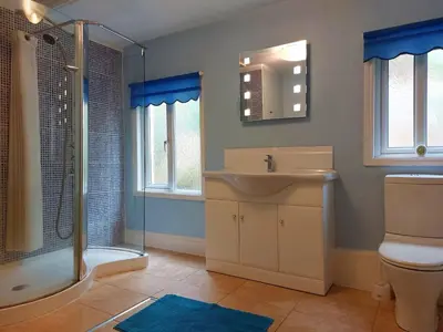 a bathroom with a sink and a shower and a toilet at South View Cottage with Terrace and Coastal Views in Fairbourne