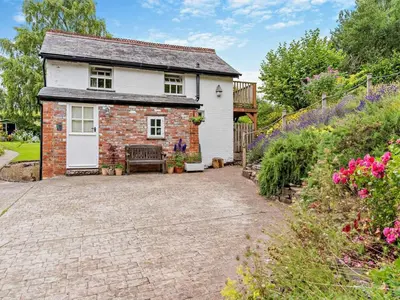 a brick cottage with a bench in the driveway at 1 Bed in Brecon oc-bn157 in Llangorse