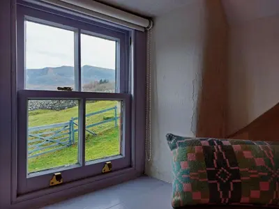 a room with a window with a view of a field at CaeEinion Cottage a Georgeous Rural Retreat Nr Dolgellau in Dolgellau
