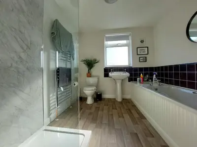 a bathroom with a tub and a sink and a toilet at Craig View Fishermans Cottage nr Harbour and Beach in Barmouth