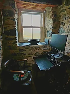 a computer sitting on a desk in a room with a window at Gallestra a Rustic, Rural Retreat Farm House Nr Dolgellau Snowdonia in Dolgellau
