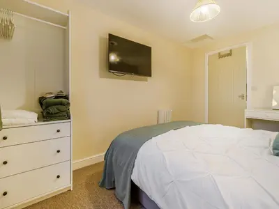 a bedroom with a bed and a dresser with a tv at Brewers Cottage-Uk45454 in Montgomery