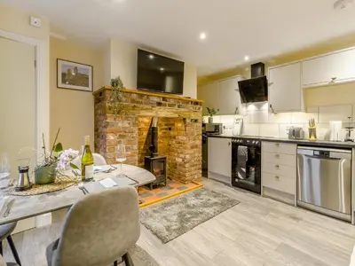a kitchen with a fireplace and a table with chairs at Brewers Cottage-Uk45454 in Montgomery